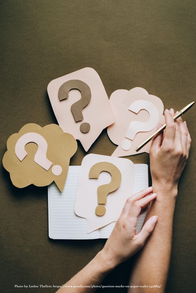 Promotional image showing hands holding a pen on top of question marks cuttings. Levels offered.