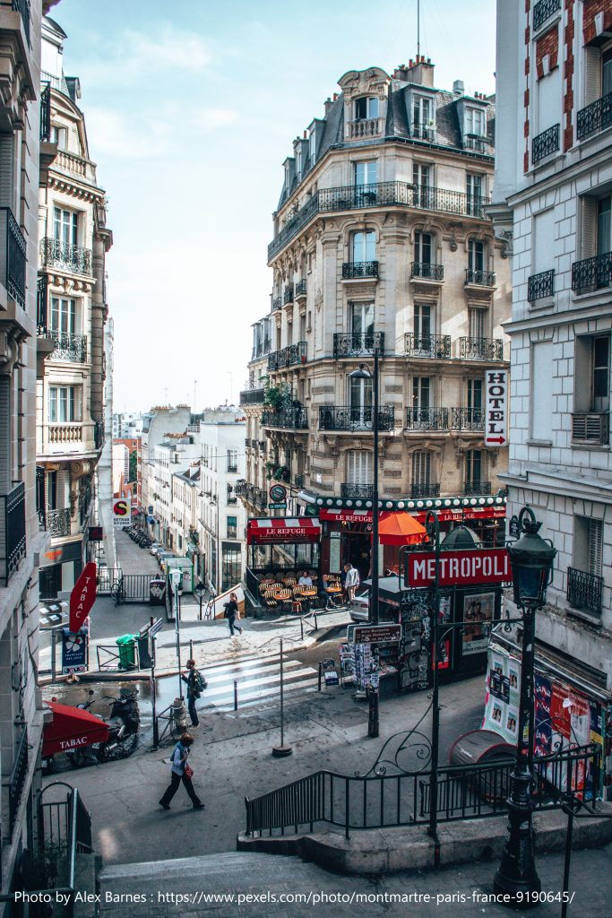 Photo of Paris street with local shops and locals walking about. 